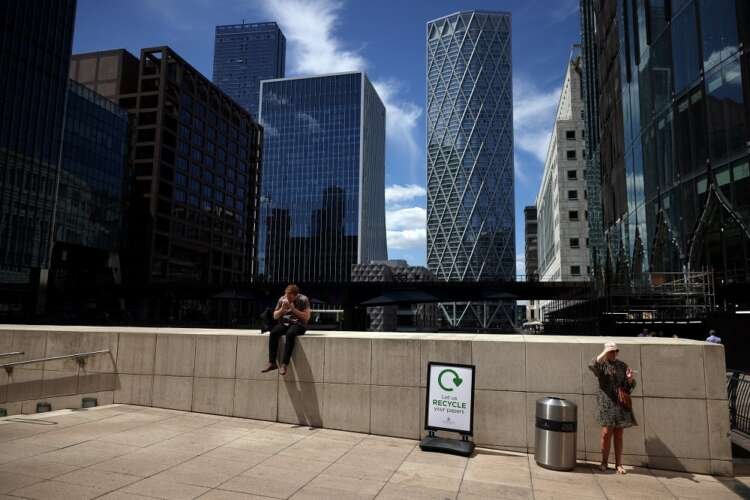 A person enjoys a sandwich in sunny London, reflecting UK's inflation impact - Global Banking & Finance Review