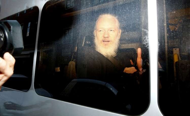 Julian Assange in a police van after his arrest, linked to extradition battle - Global Banking & Finance Review