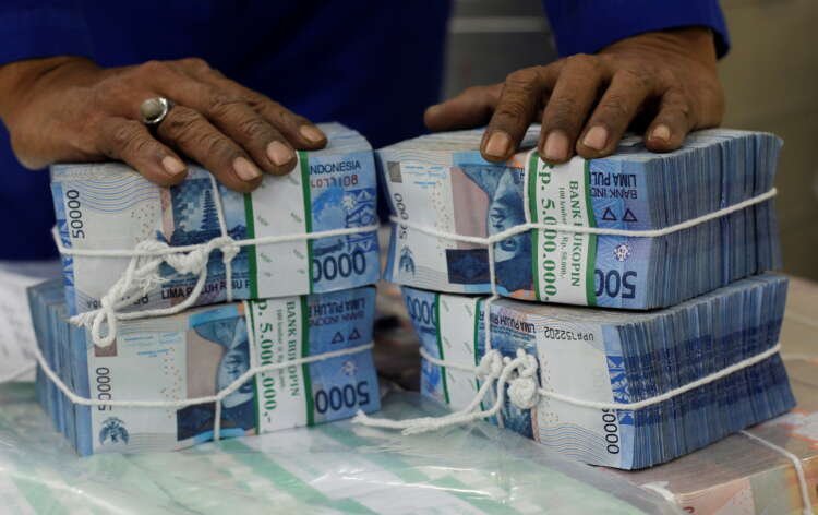 FILE PHOTO: A worker prepares bundles of rupiah bank notes in Bank Mandiri in Jakarta