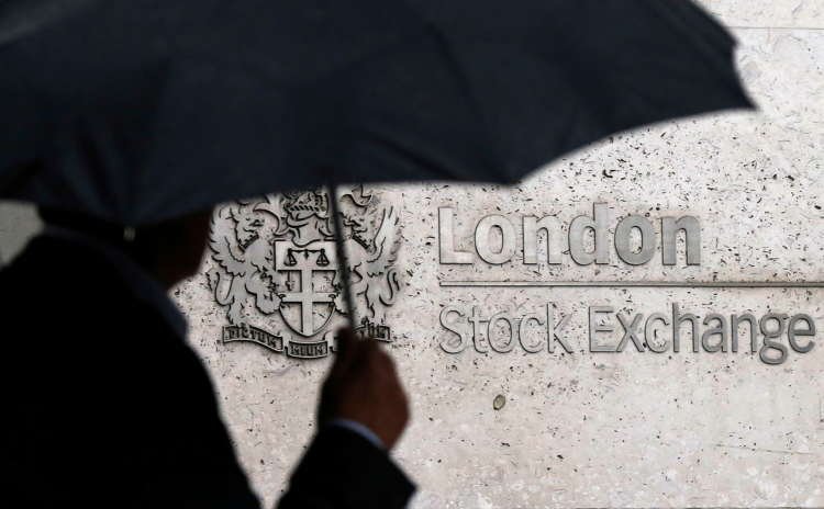 A man walks by the London Stock Exchange, highlighting trading activity in the FTSE 250 - Global Banking & Finance Review