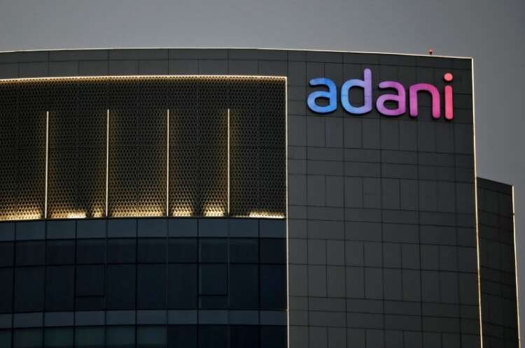Adani Group logo on building facade amidst stock market fluctuations - Global Banking & Finance Review