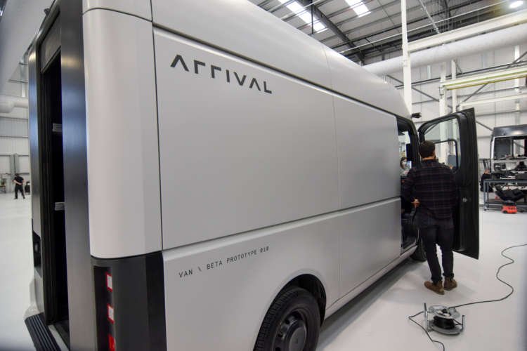 FILE PHOTO: A man stands next to a fully-electric test van, due to go into production in 2022, in Banbury
