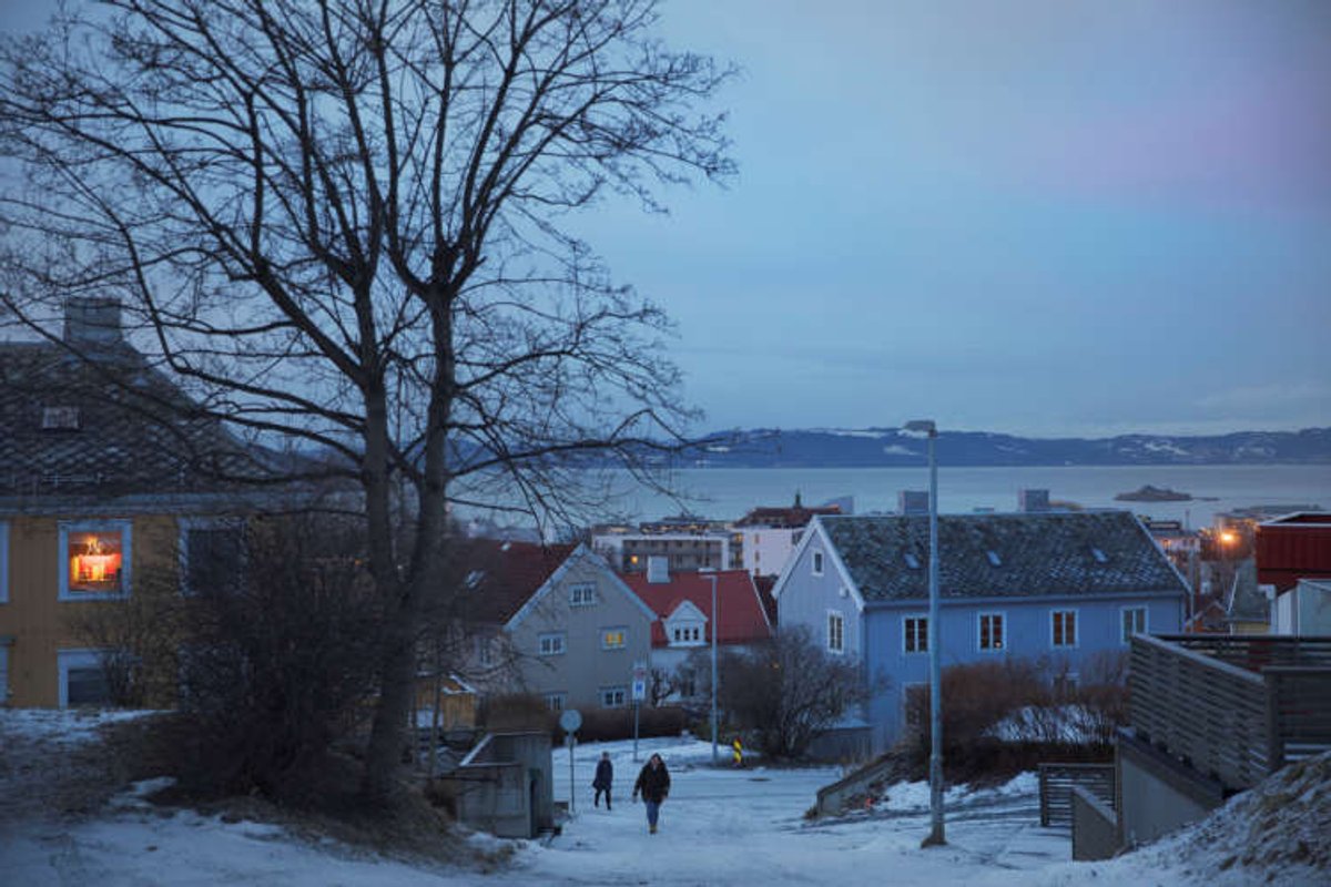 People walk through a residential street in Trondheim