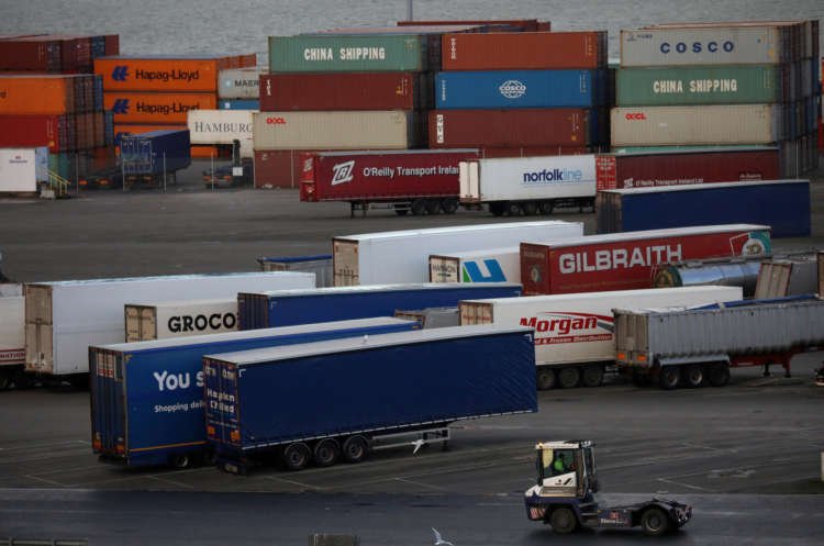 Port vehicle navigating shipping containers at Belfast amid trade cost rises - Global Banking & Finance Review