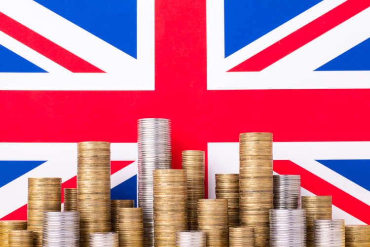 Flag of the United Kingdom with stacks of coins symbolizing SME finance - Global Banking & Finance Review