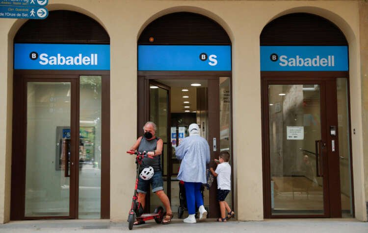 People enter a Sabadell bank office, highlighting Spain's banking sector growth - Global Banking & Finance Review