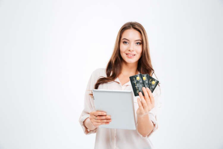 Smiling young woman holding a bank card and tablet, symbolizing banking innovation - Global Banking & Finance Review