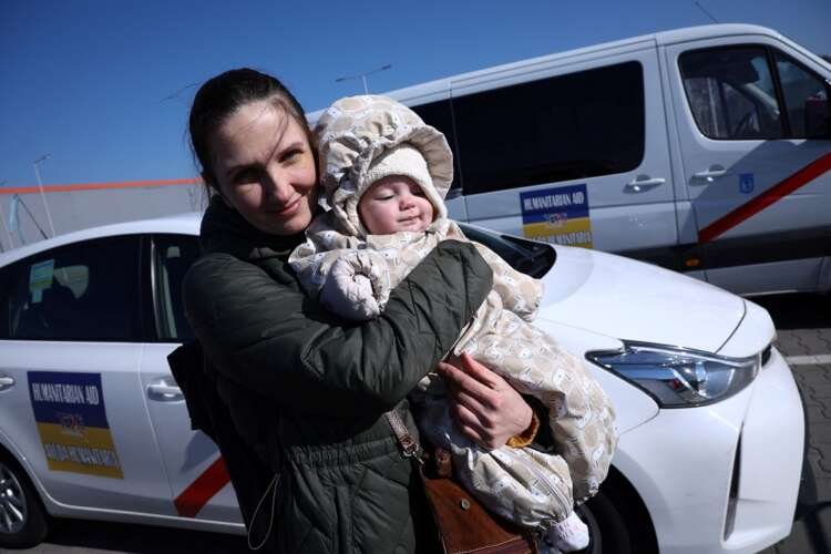Ukrainian refugee Olga holds her baby Vera while waiting for aid in Nadarzyn - Global Banking & Finance Review