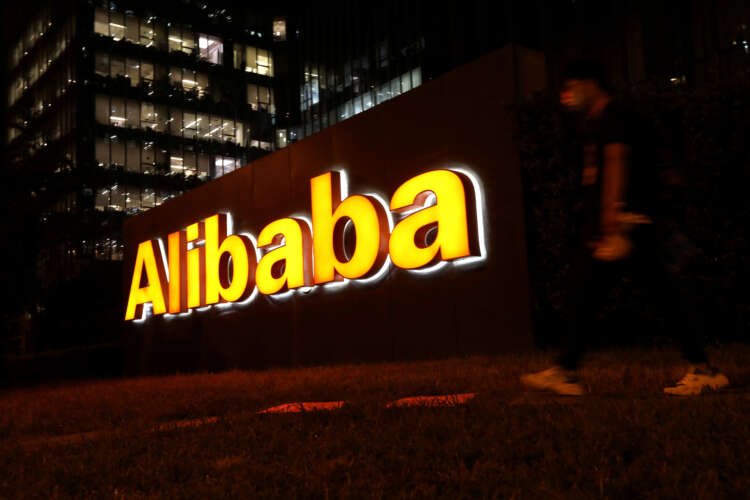 Man walks past Alibaba Group logo in Beijing, reflecting its expansion into Europe - Global Banking & Finance Review