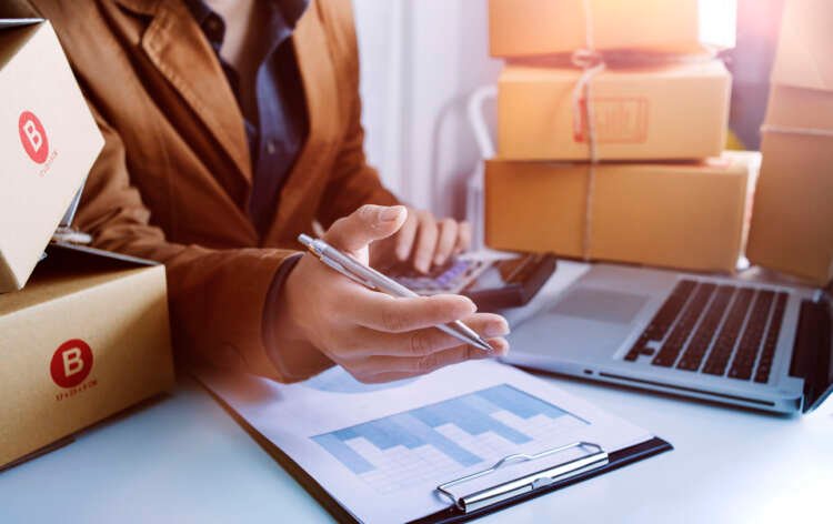 Young woman entrepreneur managing online orders while engaging customers - Global Banking & Finance Review