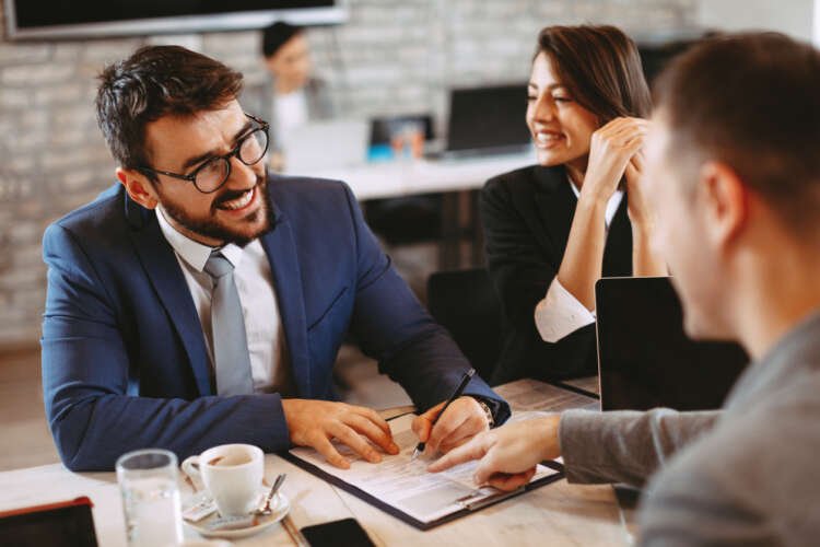 Young business couple reviewing financial contracts, highlighting Consumer Duty in banking - Global Banking & Finance Review