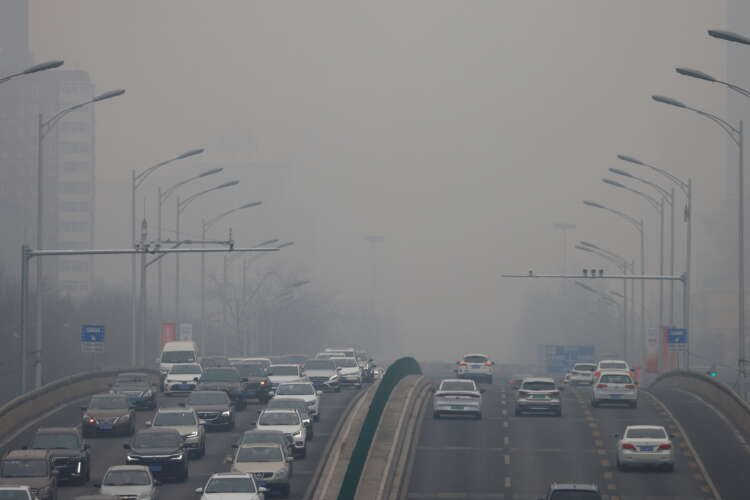 FILE PHOTO: Cars move on a road during a day with polluted air, following the outbreak of the coronavirus disease (COVID-19), in Beijing, China February 13, 2021
