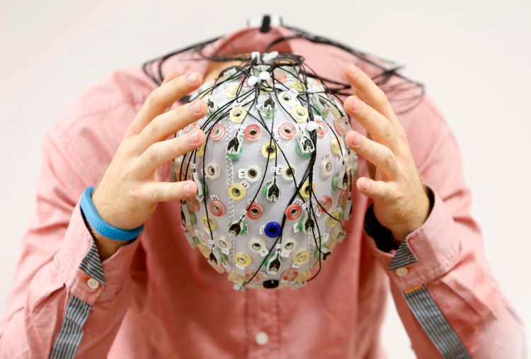 Person wearing an EEG cap measuring brain activity, highlighting advances in brain technology - Global Banking & Finance Review