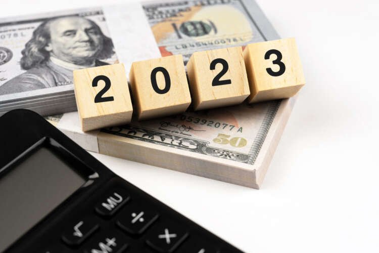 Calculator and US dollar symbolizing investment strategies for 2023 outlook - Global Banking & Finance Review