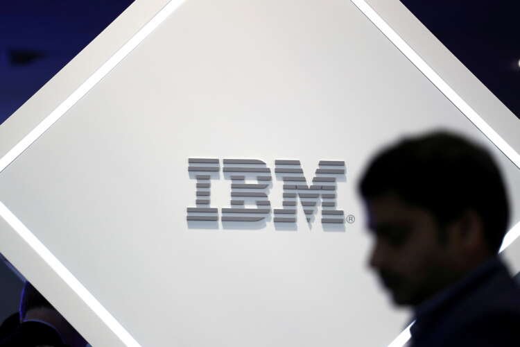 FILE PHOTO: FILE PHOTO: A man stands near an IBM logo at the Mobile World Congress in Barcelona