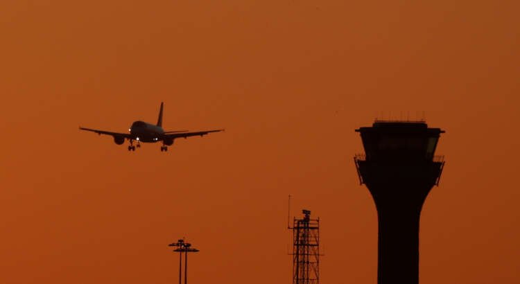 Passenger plane landing at London Luton Airport, symbolizing greener air travel funding - Global Banking & Finance Review