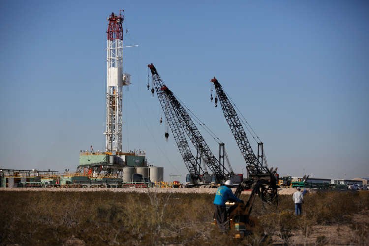 Oil worker operating a forklift near a drill rig, highlighting U.S. supply issues - Global Banking & Finance Review