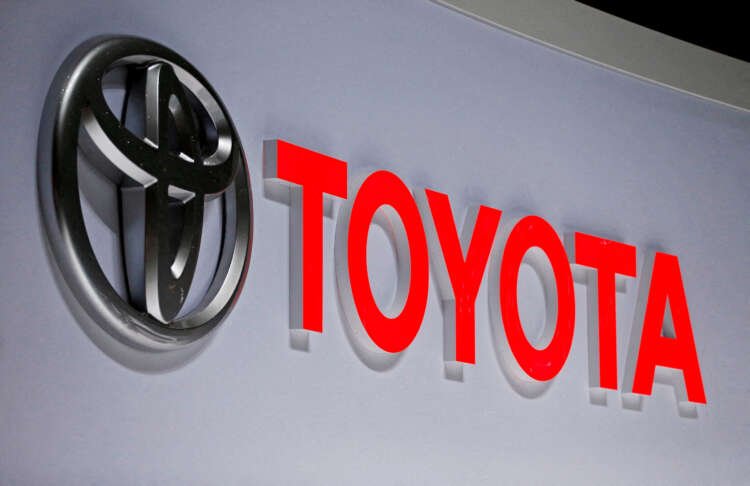 Toyota logo displayed at an auto show, reflecting the company's challenges amid chip shortage - Global Banking & Finance Review