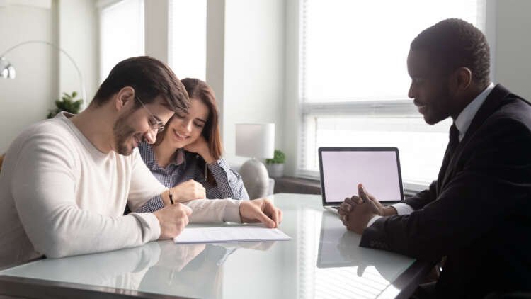 Happy young couple signing a banking contract, symbolizing customer engagement in finance - Global Banking & Finance Review