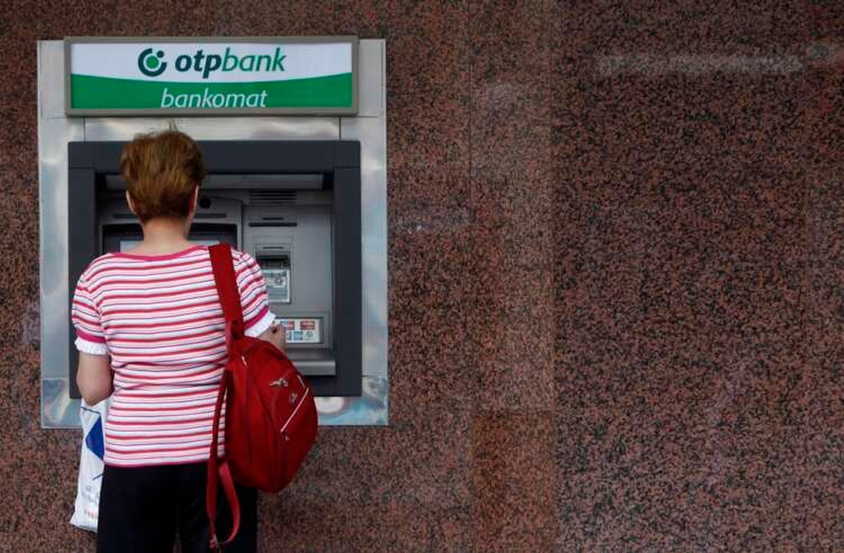A woman withdraws money from an ATM at an OTP bank in Budapest
