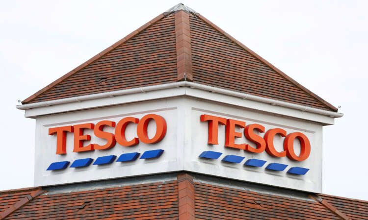 Tesco store sign with shoppers, reflecting Britain's grocery market amid easing inflation - Global Banking & Finance Review
