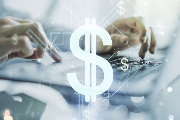 Double exposure of creative USD symbols hologram and hands typing on laptop on background. Banking and investing concept