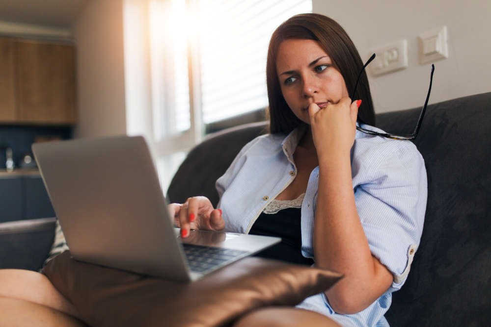 Person working remotely with laptop at home, showcasing emerging business risks - Global Banking & Finance Review