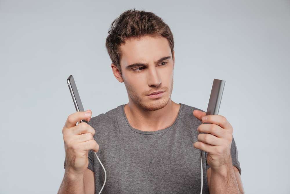 Wireless charging pad with smartphone, showcasing modern charging technology - Global Banking & Finance Review