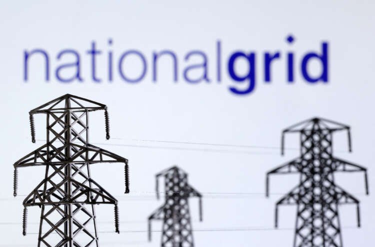 Electric power transmission pylons with National Grid logo illustrating Britain's electricity supply outlook - Global Banking & Finance Review