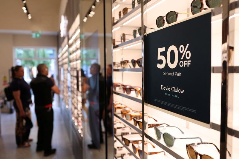 EssilorLuxottica's logo with financial graphs indicating 9.4% profit rise - Global Banking & Finance Review