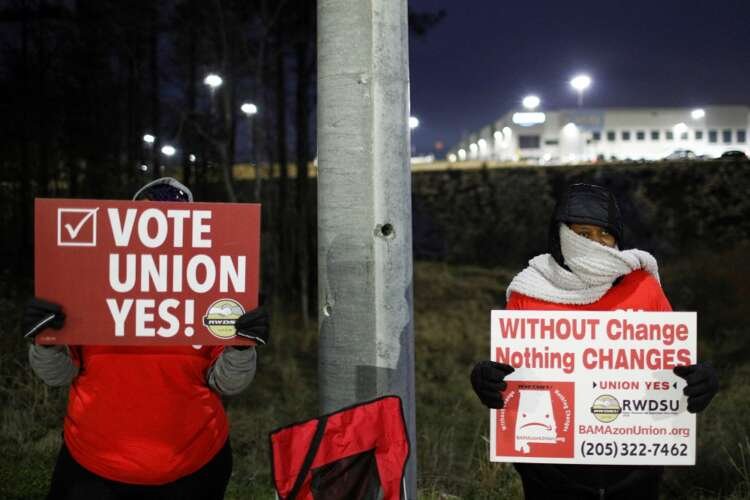 FILE PHOTO: People affiliated with RWDSU hold signs supporting unionization, in Bessemer