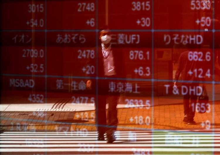 A man checks stock prices on an electronic display, reflecting market trends - Global Banking & Finance Review