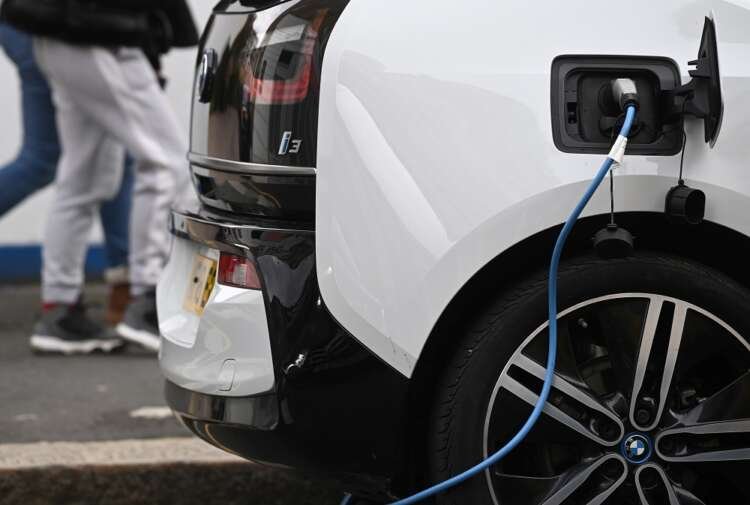 Electric vehicle charging at a roadside station, highlighting EV battery challenges - Global Banking & Finance Review