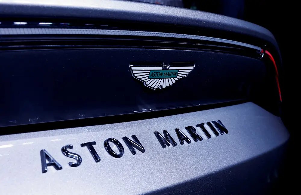 Aston Martin logo with stock market chart showing decline - Global Banking & Finance Review