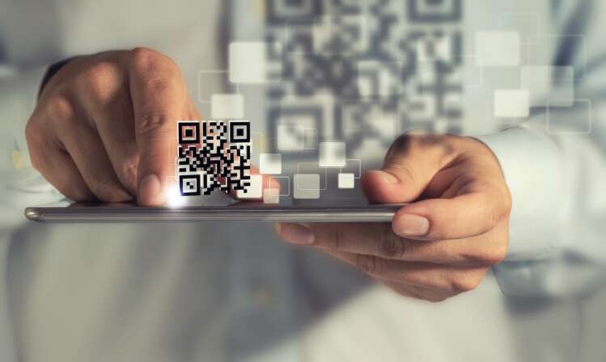 Person scanning a QR code on a tablet, illustrating alternative payments in finance - Global Banking & Finance Review