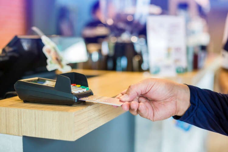 Consumer using a debit card at a payment terminal, showcasing Chile's payment trends - Global Banking & Finance Review