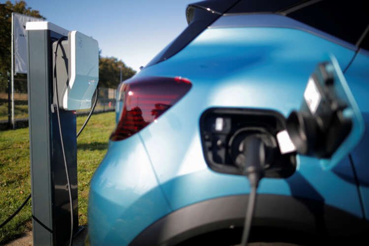 Renault Captur hybrid car charging at a dealership, showcasing electric vehicle sales - Global Banking & Finance Review