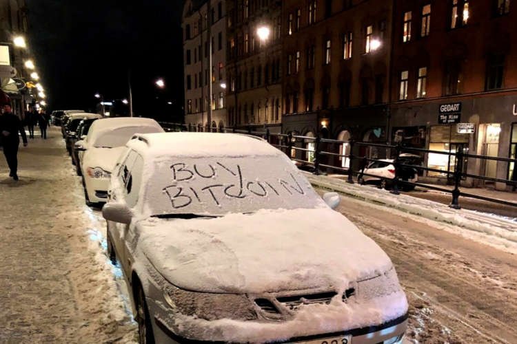 FILE PHOTO: A car with a sign “Buy Bitcoin” written in snow is pictured in Stockholm