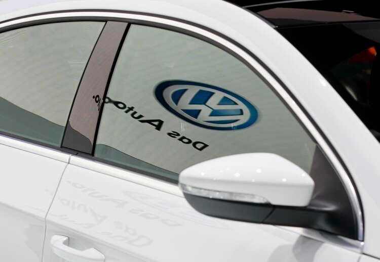 Volkswagen logo reflecting on a car window, highlighting IG Metall's concerns - Global Banking & Finance Review
