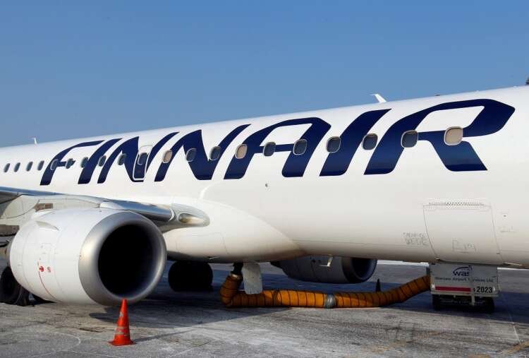 Finnair airplane at Warsaw airport, reflecting cost-cutting strategy - Global Banking & Finance Review