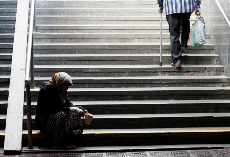 Elderly woman begs for money in an underpass in central Kyiv