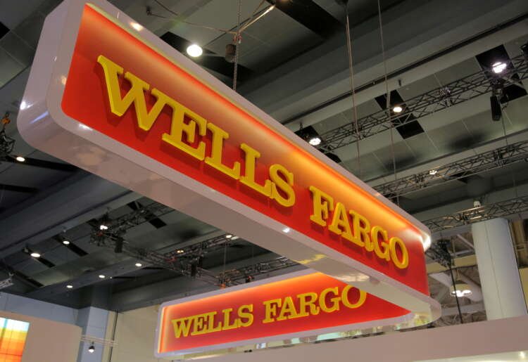 Wells Fargo logo displayed at a banking conference, highlighting asset restriction concerns - Global Banking & Finance Review