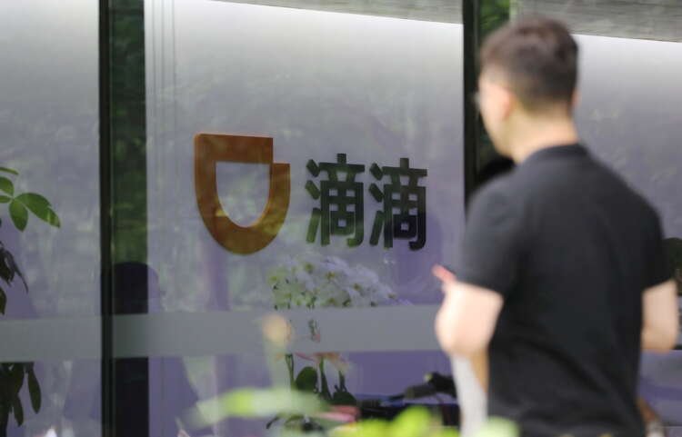 FILE PHOTO: Man walks past the headquarters building of Chinese ride-hailing service Didi in Beijing
