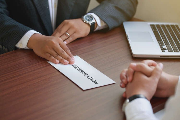 Hand holding a resignation letter symbolizing the Great Resignation in financial services - Global Banking & Finance Review