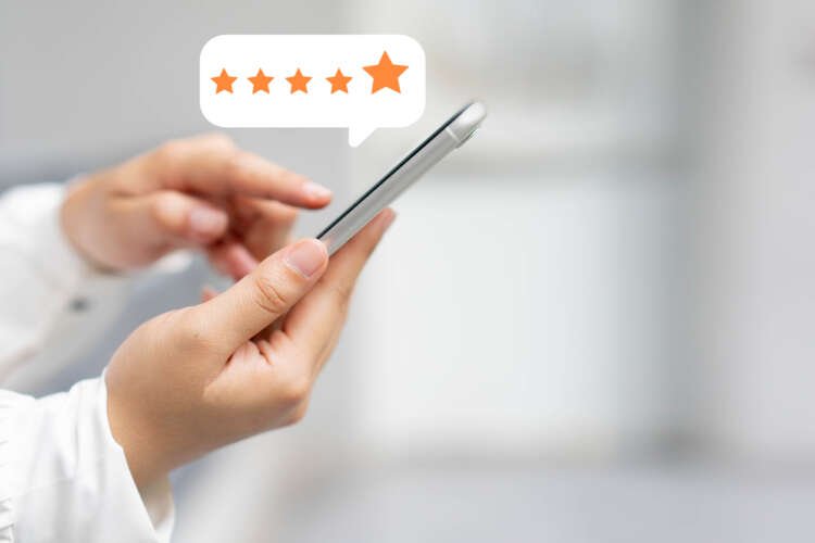 Close-up of a woman's hand rating a service on a smartphone - Super Apps in Fintech - Global Banking & Finance Review