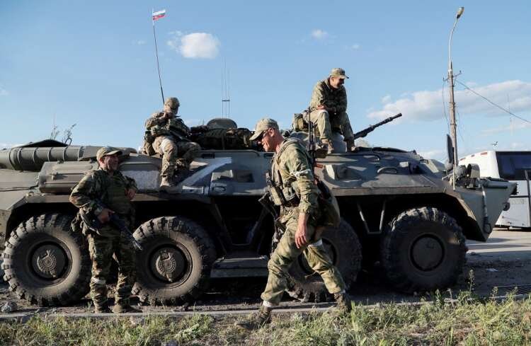 Service members of pro-Russian troops stand guard in Mariupol amid Ukraine war - Global Banking & Finance Review