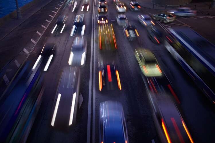 Motion blurred car traffic at night illustrating mobility in transportation and logistics - Global Banking & Finance Review