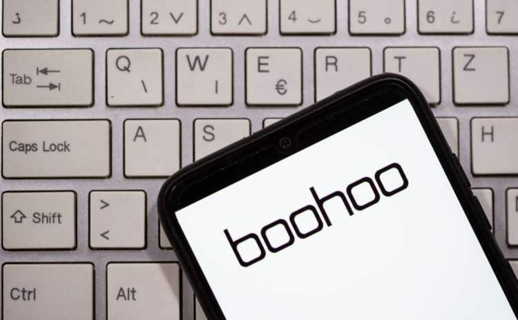 Illustration of a smartphone displaying the Boohoo logo on a keyboard, representing Boohoo's financial strategies - Global Banking & Finance Review