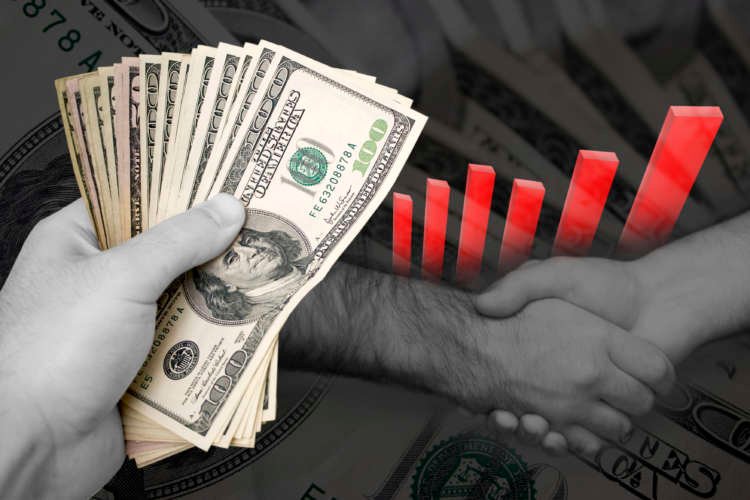 A handshake over a cash stack symbolizes successful business dealings in finance - Global Banking & Finance Review