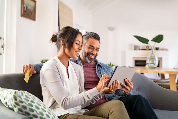 Multiethnic mid adult couple using digital tablet at home